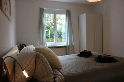 a bedroom with a bed with two pillows and a window at Nice apartment with sun terrace in St. Gallen