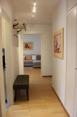 a living room with a bench and a room with a couch at Nice apartment with sun terrace in St. Gallen