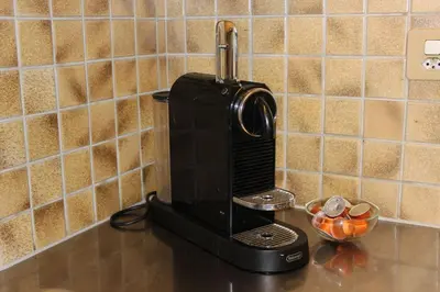 a coffee maker on a counter with a bowl of oranges at Nice apartment with sun terrace in St. Gallen