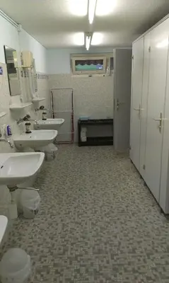 a bathroom with three sinks and two toilets at Camping Schönengrund in Schönengrund