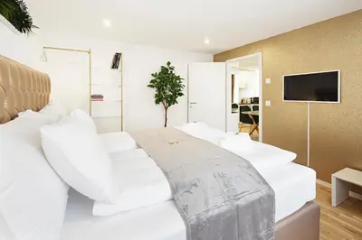 a white bed with white pillows in a room at VISIMO Apartments Steigerstrasse St Gallen - Modern Living near OLMA & Hospital in St. Gallen