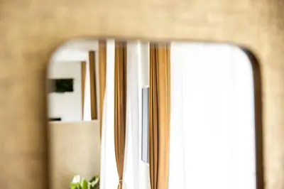 a mirror with a reflection of a window at VISIMO Apartments Steigerstrasse St Gallen - Modern Living near OLMA & Hospital in St. Gallen