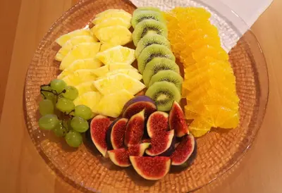a plate of fruit and vegetables on a glass plate at Hotel Garni Arnegg in Arnegg