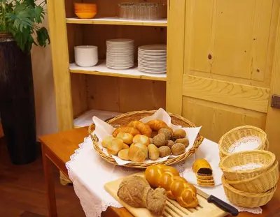 a table with a basket of bread and a basket of pastries at Hotel Garni Arnegg in Arnegg