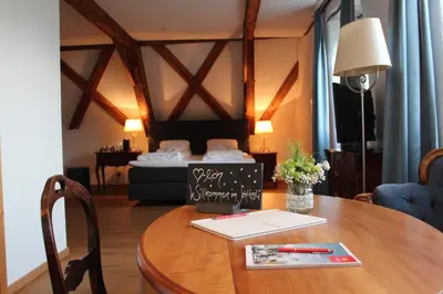 a room with a table with a bed in the background at Hotel Restaurant Schlössli Sax in Sax
