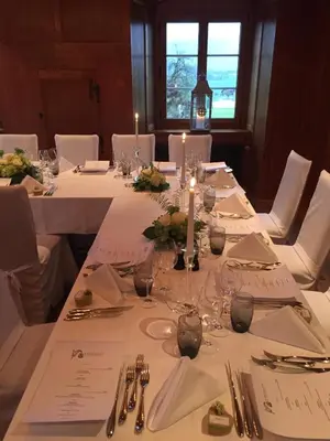 a table with white table cloths and candles on it at Hotel Restaurant Schlössli Sax in Sax