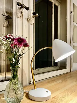 a lamp sitting next to a vase with flowers at Villa Bergruh in St. Gallen