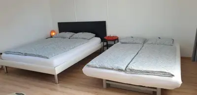 two twin beds in a room with at Lake Getaway Apartment with Private entrance, right on the Lake Constance cycle path, barbecue area, free wifi, Netflix and free bikes in Salmsach
