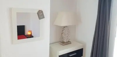 a mirror on a wall next to a table with a lamp at Lake Getaway Apartment with Private entrance, right on the Lake Constance cycle path, barbecue area, free wifi, Netflix and free bikes in Salmsach