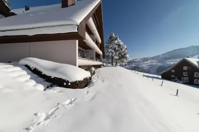 a snow covered street in front of a building at Vista Montagna in Unterwasser