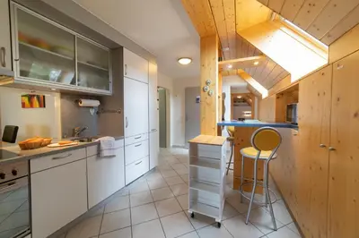 a kitchen with white cabinets and a counter top at Vista Montagna in Unterwasser