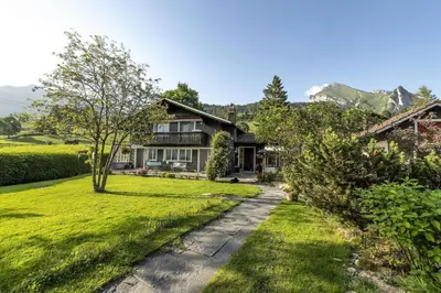 a home in the mountains with a grass yard at Capanna in Wildhaus