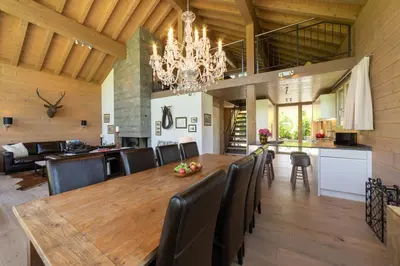 a dining room with a wooden table and a chandelier at Primula in Wildhaus