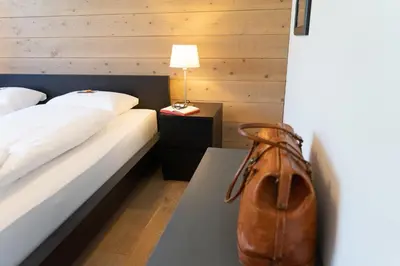 a hotel room with two beds and a brown purse at Primula in Wildhaus