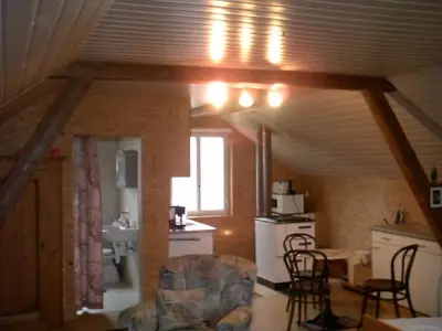 a kitchen and a living room with a table and chairs at Appartement Unterstädeli Engelburg SG in Wittenbach