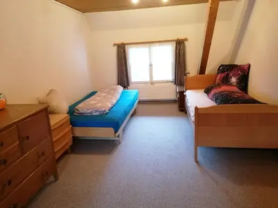 a bedroom with a bed and a couch and a window at Schwellbrunn,Ferienwohnung mit Säntissicht in Schwellbrunn