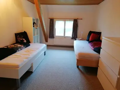 a room with two beds and a couch and a window at Schwellbrunn,Ferienwohnung mit Säntissicht in Schwellbrunn