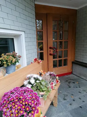 a porch with a bunch of flowers in front of a door at Schwellbrunn,Ferienwohnung mit Säntissicht in Schwellbrunn