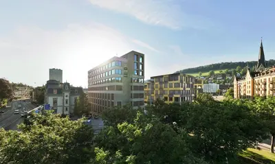 a view of a city with buildings and trees at Tailormade Hotel LEO St Gallen in St. Gallen