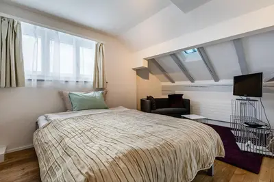 a bedroom with a bed and a clock on the wall at Aparthotel Mama Home Stankt Georgen in St. Gallen