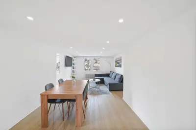 a dining room and living room with a table and a couch at book2stay - Apartments Herisau in Herisau
