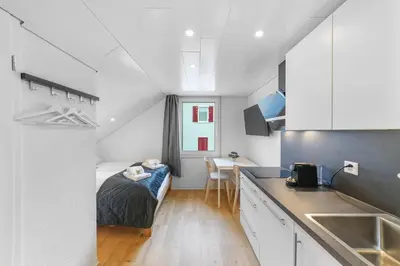 a small room with a bed and a kitchen at book2stay - Apartments Herisau in Herisau