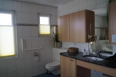 a bathroom with a sink and a toilet and window at Gästehaus Aemisegg in Sankt Peterzell