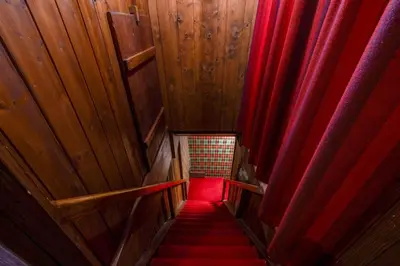 a stairway with red curtains and a red seat at Schloessli Herrenhof in Herrenhof
