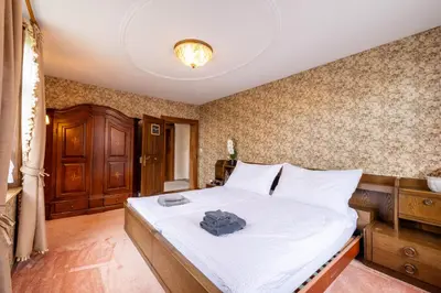 a bedroom with a large bed with white sheets at Schloessli Herrenhof in Herrenhof