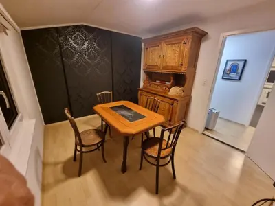 a dining room with a wooden table and chairs at 24-7 Rooms in Sennwald