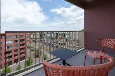 a balcony with a table and chairs and a view of a city at b-smart hotel Arbon in Arbon