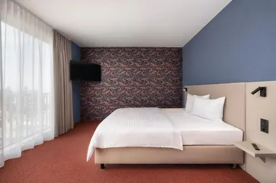 a bedroom with a white bed and a blue wall at b-smart hotel Arbon in Arbon