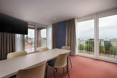 a conference room with a table and chairs and windows at b-smart hotel Arbon in Arbon