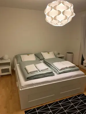 a bedroom with a bed under a chandelier at Amazing lakeview flat Horn in Horn