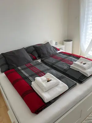 a bed with black and red blankets and towels on it at Amazing lakeview flat Horn in Horn