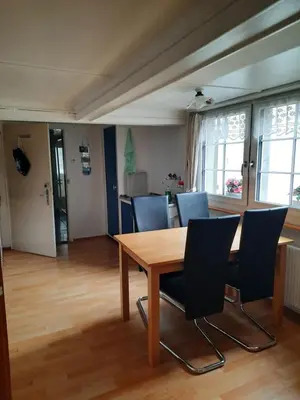 a dining room with a wooden table and chairs at Vreni`s Ferienwohnung in Gais