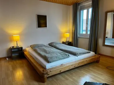 a bedroom with a bed with two lamps on two tables at Charmante und zentrale Wohnung am Weiherpark Arbon in Arbon