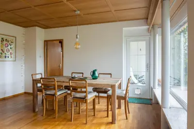 a dining room with a wooden table and chairs at Luxury apartment with terrace and garden free parking smart TV etc in St. Gallen