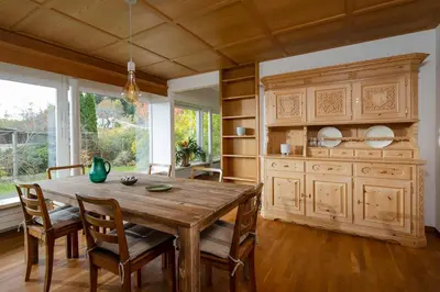 a dining room with a wooden table and chairs at Luxury apartment with terrace and garden free parking smart TV etc in St. Gallen