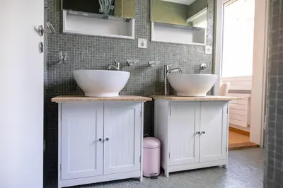 a bathroom with two sinks and two cabinets at Luxury apartment with terrace and garden free parking smart TV etc in St. Gallen