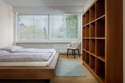 a bedroom with a bed and a window and a chair at Luxury apartment with terrace and garden free parking smart TV etc in St. Gallen