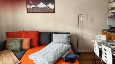 a living room with a couch with an orange blanket at Beautiful holiday apartment in Wildhaus Toggenburg in Wildhaus