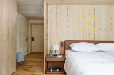 a bedroom with a bed and a wooden wall at Appenzeller Huus Löwen in Gonten