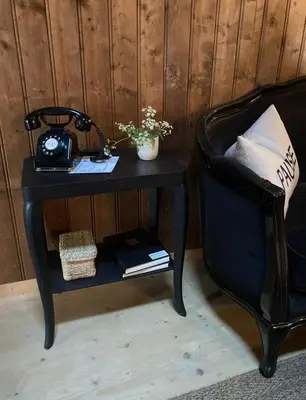 a black table with a telephone and a chair at Fischerhäuser Romanshorn in Romanshorn