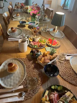 a long wooden table with plates of food on it at Fischerhäuser Romanshorn in Romanshorn