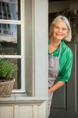 a woman standing in a window looking at the camera at Fischerhäuser Romanshorn in Romanshorn