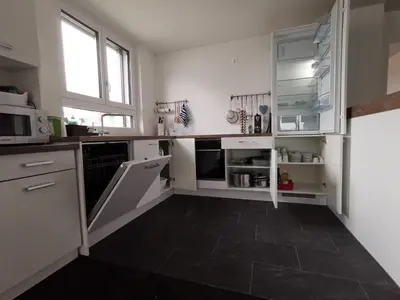a kitchen with white cabinets and a black tile floor at Ferienwohnung Hirschen in Gossau