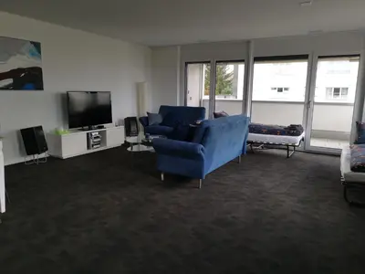 a living room with two blue chairs and a tv at Ferienwohnung Hirschen in Gossau
