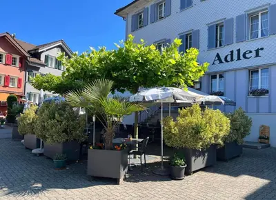 a table and umbrella in front of a building at Landgasthof Adler in 9304 Bernhardzell in Häggenschwil