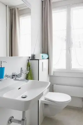 a white bathroom with a sink and a toilet at Landgasthof Adler in 9304 Bernhardzell in Häggenschwil